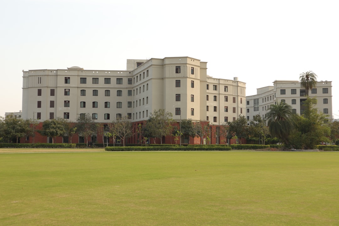 a large white building sitting on top of a lush green field