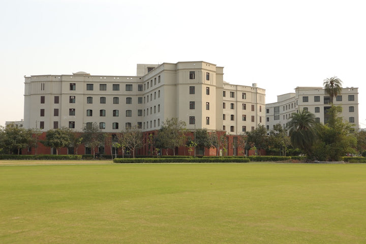 a large white building sitting on top of a lush green field