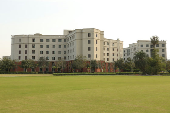 a large white building sitting on top of a lush green field