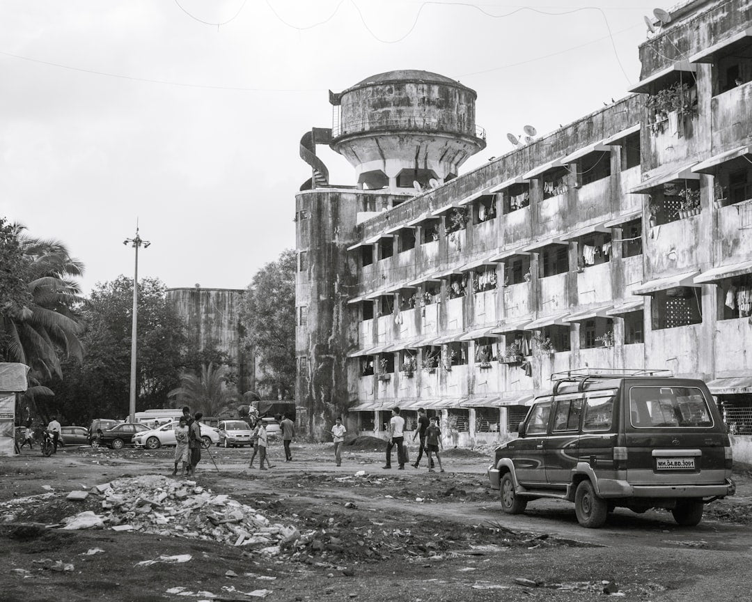 A dilapidated building with a tall water tower.